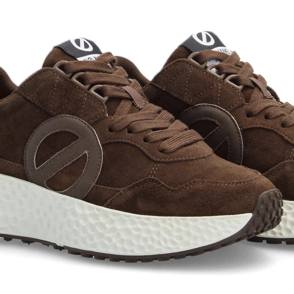 Gros plan sur les détails en cuir velours et le logo latéral ton sur ton des baskets Carter Jogger NO NAME