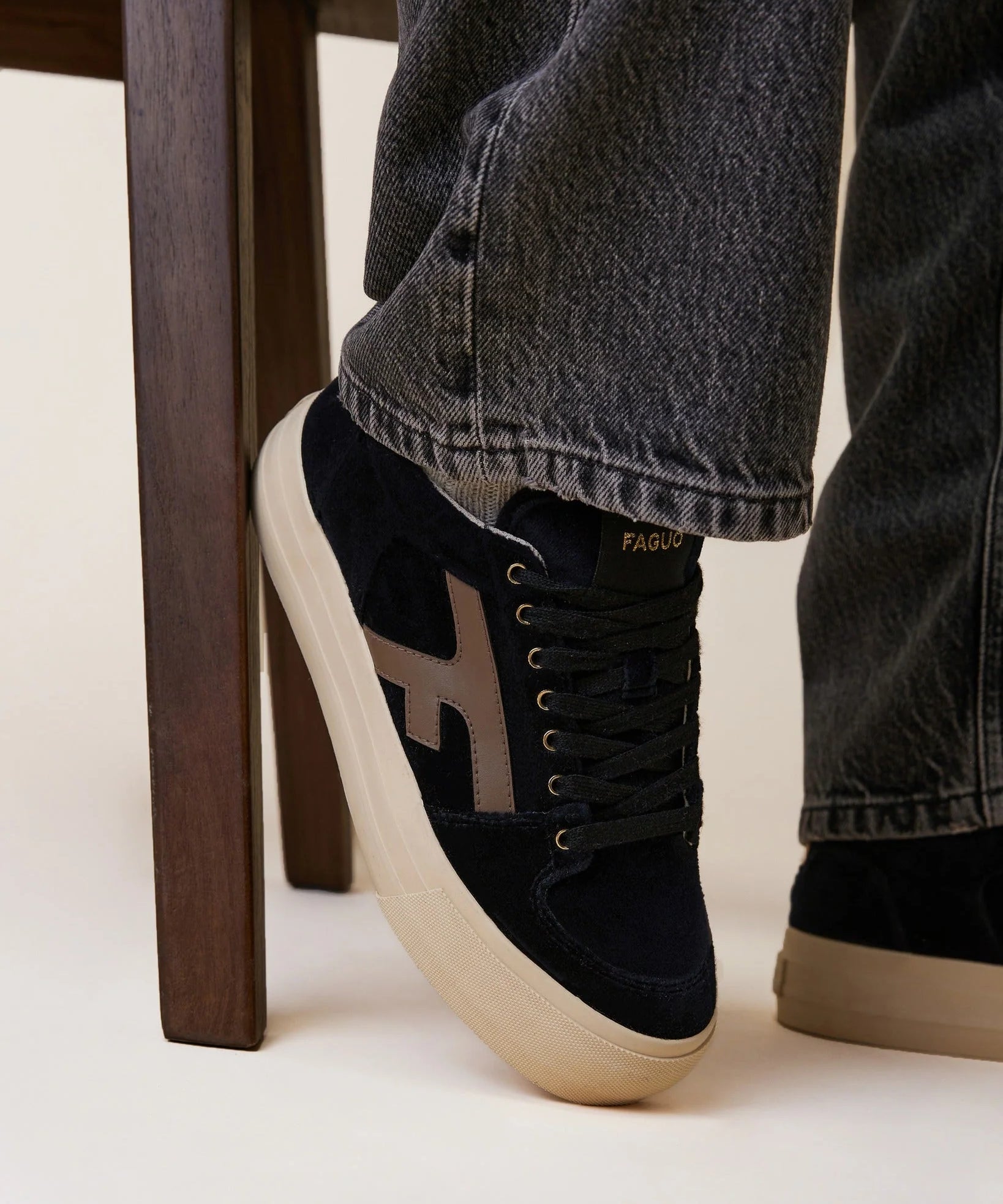 Tennis basses compensées Walnut FAGUO en velours noir portées avec un jean brut