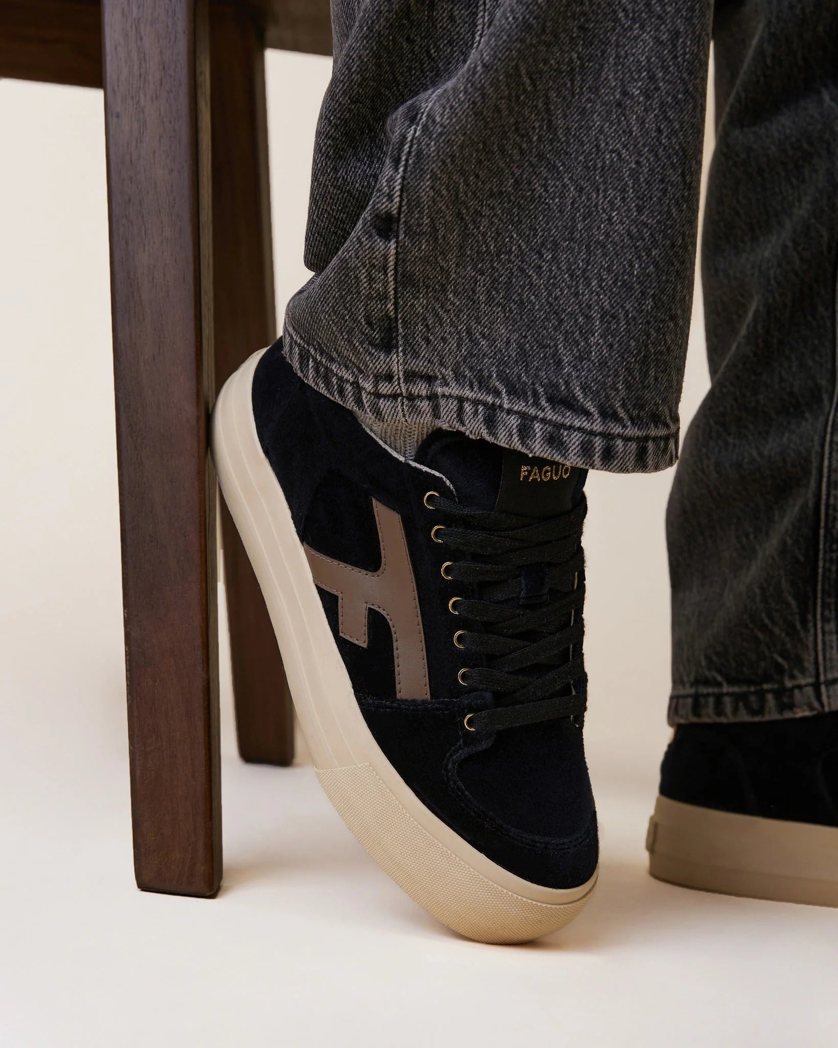 Tennis basses compensées Walnut FAGUO en velours noir portées avec un jean brut