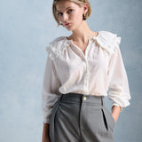 Blouse romantique en coton bio écru PETITE MENDIGOTE Constance avec immense col en broderie anglaise portée avec un pantalon de tailleur gris
