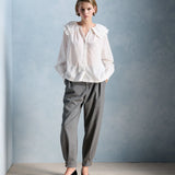 Silhouette complète avec la blouse Constance écru PETITE MENDIGOTE, pantalon de costume gris et escarpins vernis noirs