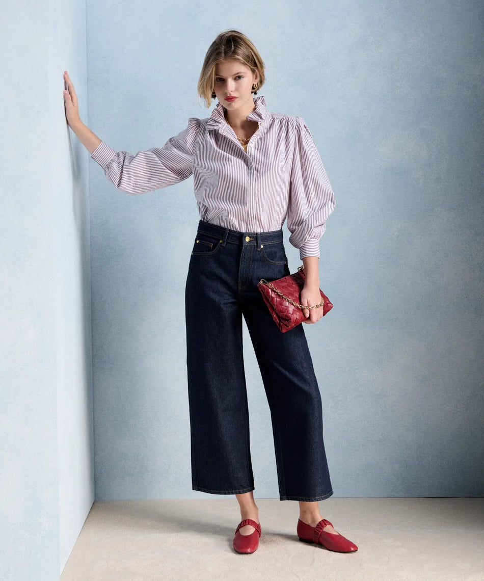 Silhouette complète avec la blouse Ernestine bordeaux PETITE MENDIGOTE, pantalon en denim large et accessoires rouges