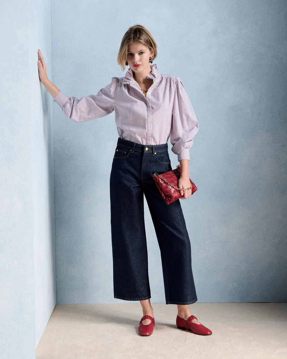Silhouette complète avec la blouse Ernestine bordeaux PETITE MENDIGOTE, pantalon en denim large et accessoires rouges