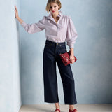 Silhouette complète avec la blouse Ernestine bordeaux PETITE MENDIGOTE, pantalon en denim large et accessoires rouges