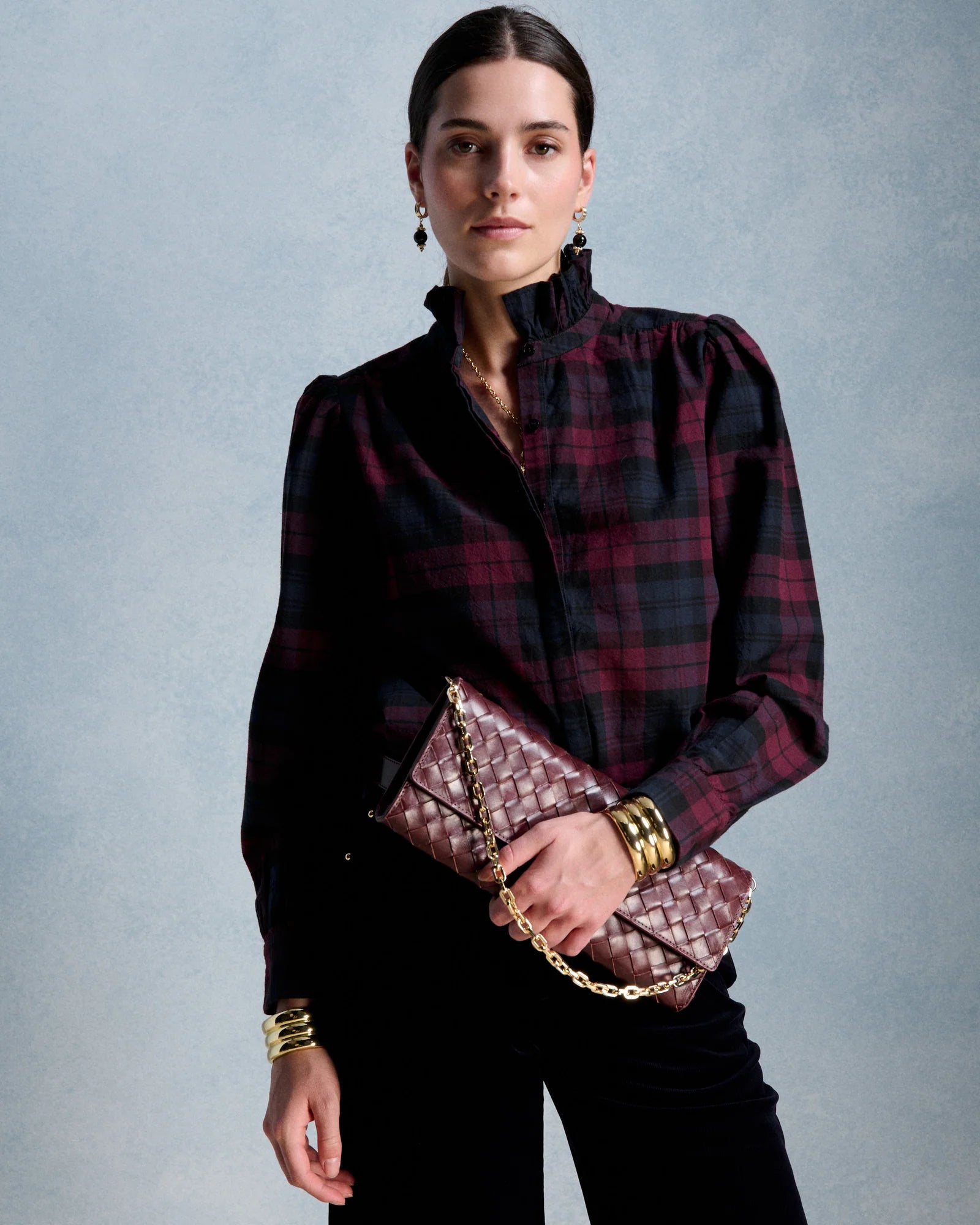 Blouse romantique à carreaux marine et bordeaux PETITE MENDIGOTE Ernestine avec col montant volanté portée avec un sac matelassé bordeaux et pantalon noir