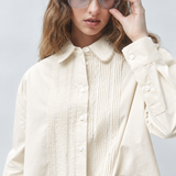 Gros plan sur le col en guipure et le plastron plissé de la blouse blanc cassé SUNCOO FEMME Libre