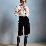 Silhouette complète avec la blouse écru Milady PETITE MENDIGOTE, bermuda en velours marron et bottes hautes en cuir noir