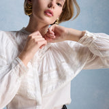 Zoom sur les détails du grand volant cape, des boutons et des poignets en dentelle de la blouse Milady PETITE MENDIGOTE