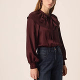Modèle portant la blouse satinée prune Satia DES PETITS HAUTS avec un jean brut