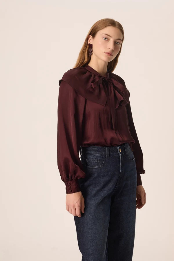 Modèle portant la blouse satinée prune Satia DES PETITS HAUTS avec un jean brut