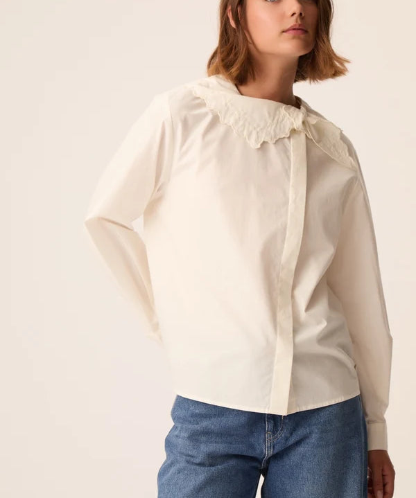 Modèle portant la blouse en popeline écru Soline DES PETITS HAUTS avec un jean bleu