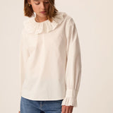 Modèle portant la blouse écru Solinette DES PETITS HAUTS avec un jean bleu