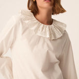 Gros plan sur le col rond volanté et la broderie anglaise de la blouse écru Solinette DES PETITS HAUTS