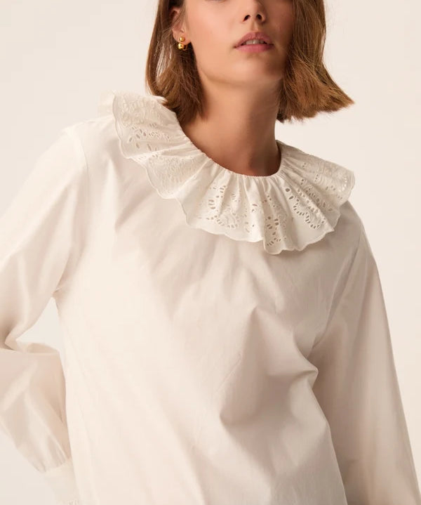 Gros plan sur le col rond volanté et la broderie anglaise de la blouse écru Solinette DES PETITS HAUTS