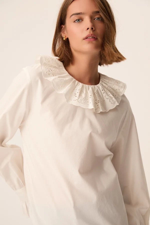 Gros plan sur le col rond volanté et la broderie anglaise de la blouse écru Solinette DES PETITS HAUTS