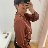 Vue de profil de la blouse Viramette bordeaux VILA mettant en valeur les broderies des manches