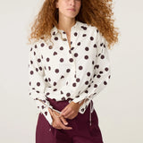 Plan moyen de la blouse Ada FABIENNE CHAPOT à pois et cœurs bordeaux portée avec un pantalon assorti