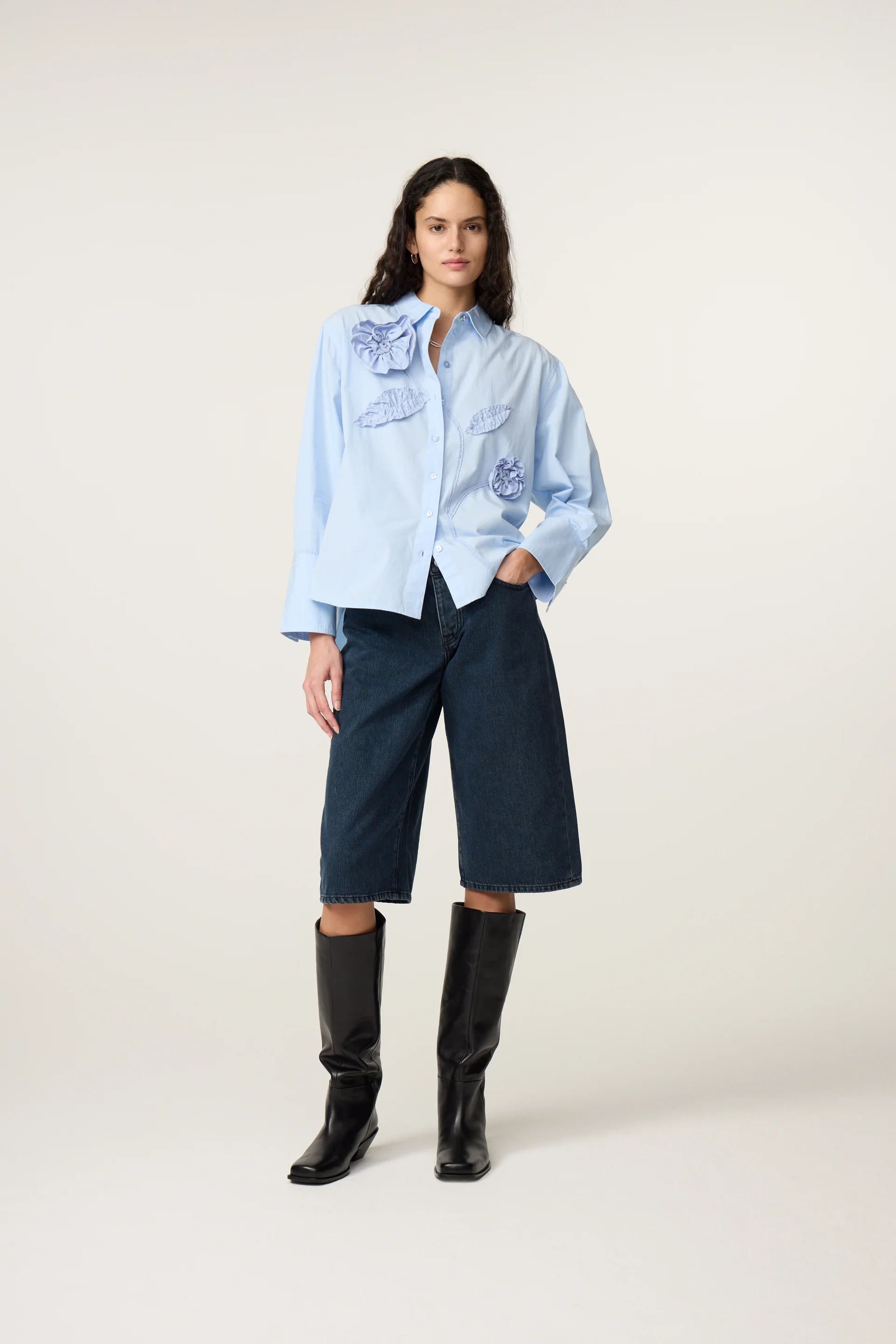 Vue en pied de la blouse ample bleu clair FABIENNE CHAPOT portée avec un bermuda en jean et des bottes hautes