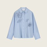 Blouse Iced Blue à fleurs en relief FABIENNE CHAPOT présentée à plat sur fond neutre