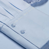 Gros plan sur les poignets larges structurés et le détail de broderie de la blouse FABIENNE CHAPOT