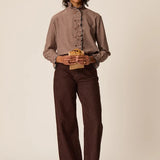Silhouette complète modèle portant la blouse vichy Sulli DES PETITS HAUTS avec un pantalon marron large
