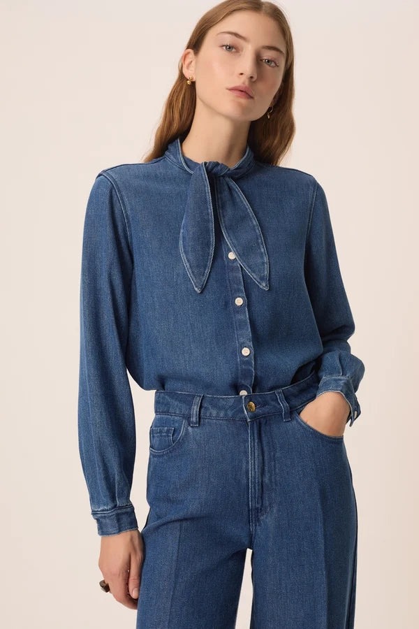 Vue de face de la blouse en denim fluide Lenora DES PETITS HAUTS avec col bandana à nouer et un jean