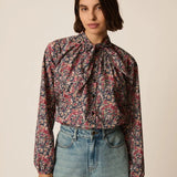 Modèle portant la blouse lavallière fleurie Rainbow Taya DES PETITS HAUTS avec un berrmuda en jean