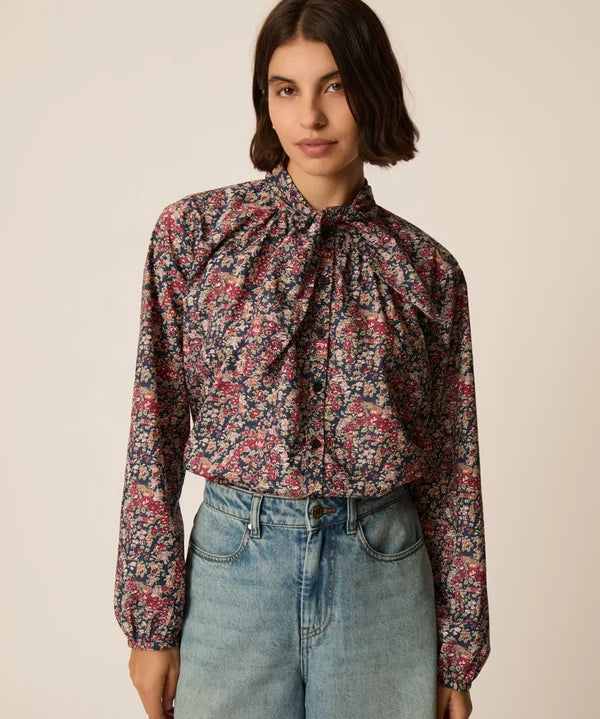 Modèle portant la blouse lavallière fleurie Rainbow Taya DES PETITS HAUTS avec un berrmuda en jean