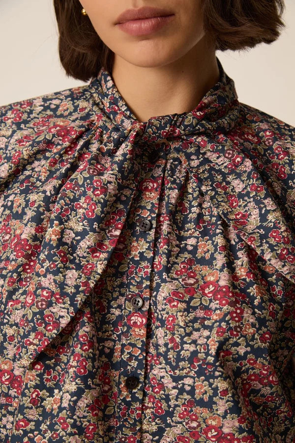 Zoom sur le nœud lavallière et le motif fleuri Liberty Taya bleu marine de la blouse Rainbow DES PETITS HAUTS