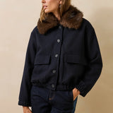 Mannequin portant le blouson bomber marine Galane LA FÉE MARABOUTÉE avec son col fausse fourrure marron et un jean brut