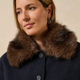 Gros plan sur la fausse fourrure marron amovible du col et le premier bouton du blouson Galane marine