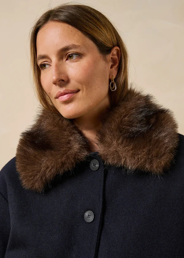 Gros plan sur la fausse fourrure marron amovible du col et le premier bouton du blouson Galane marine