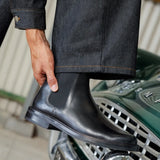 Visuel porté de profil des Chelsea boots en cuir lisse noir intense BOBBIES HOMME Grant avec un pantalon en jean