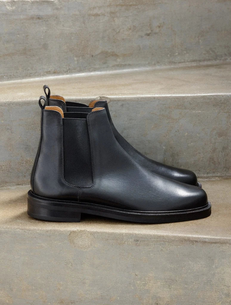Vue de profil des bottines noires à élastique Grant BOBBIES HOMME posées sur des marches