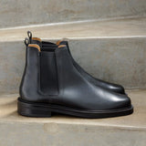 Vue de profil des bottines noires à élastique Grant BOBBIES HOMME posées sur des marches