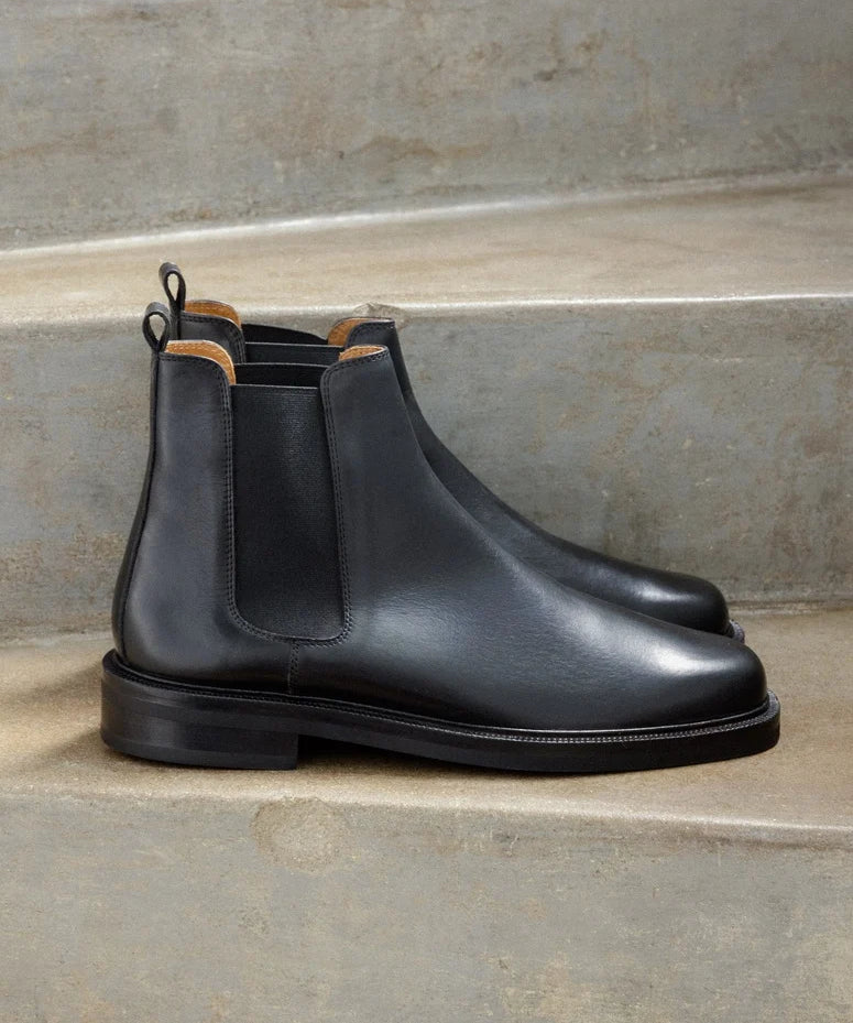 Vue de profil des bottines noires à élastique Grant BOBBIES HOMME posées sur des marches