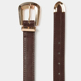 Zoom sur les détails métalliques dorés de la boucle et de l'extrémité de la ceinture bordeaux MORGAN