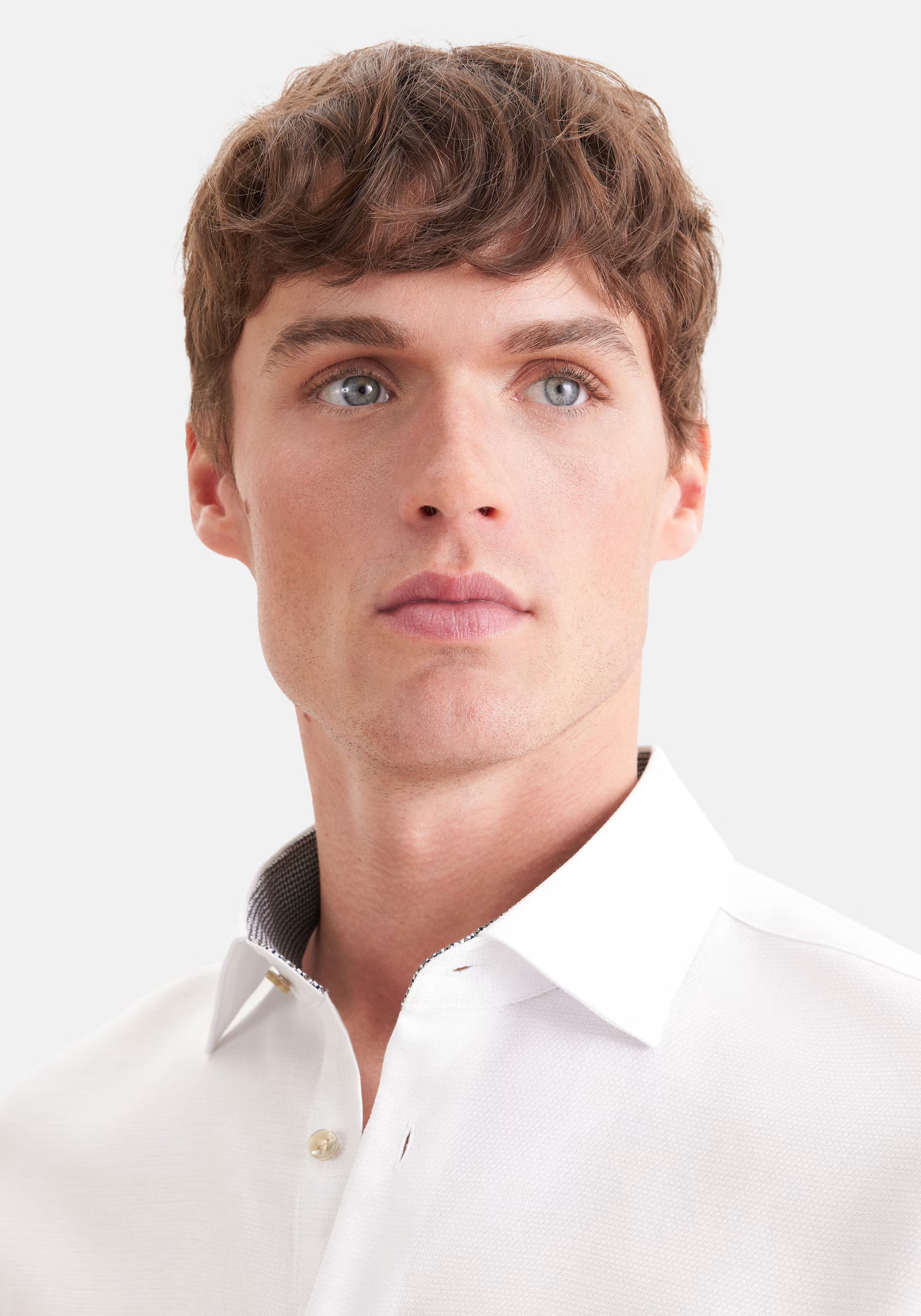 Gros plan du col Kent et du tissu en coton dobby texturé de la chemise blanche Seidensticker