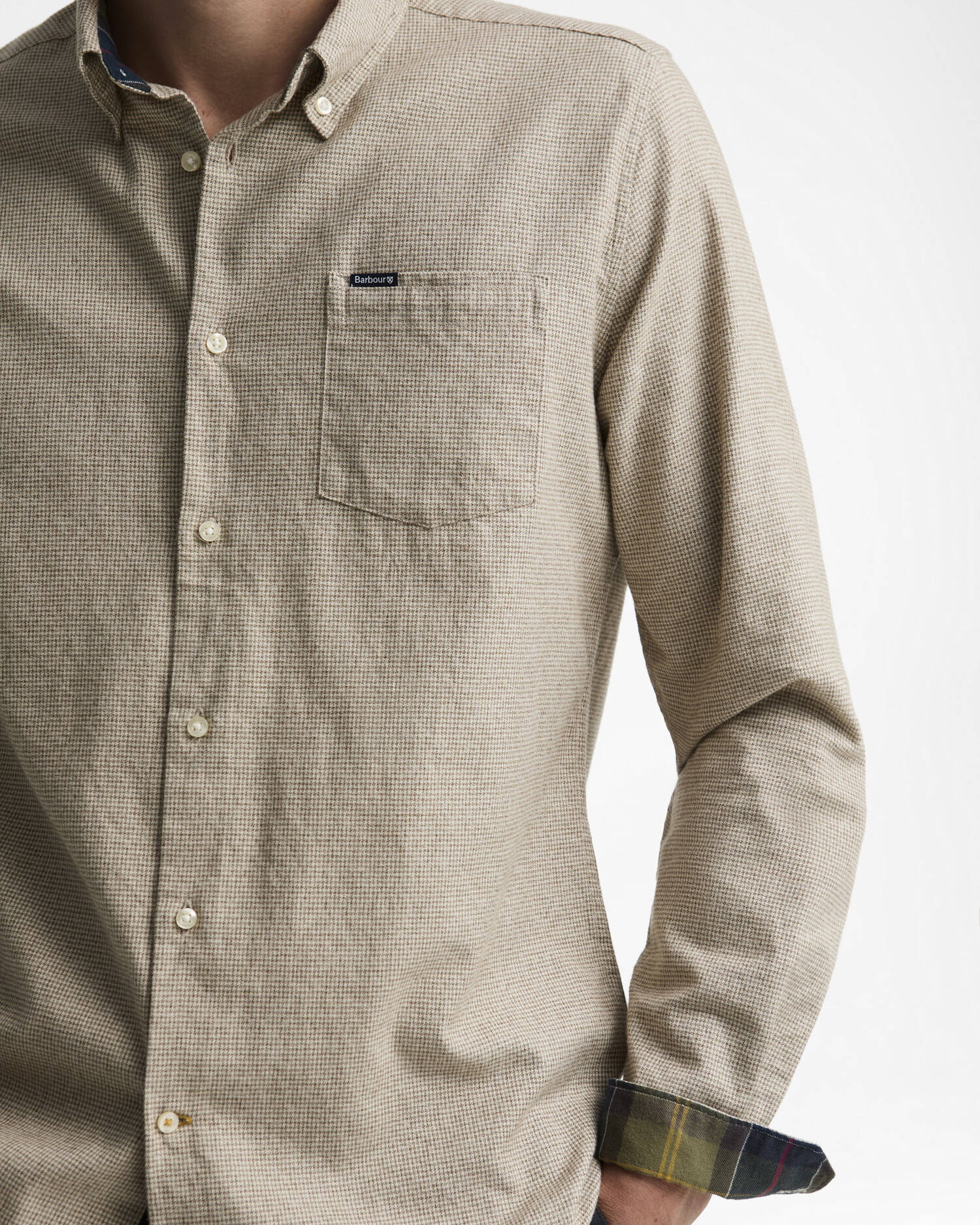 Gros plan sur la chemise pierre Barbour montrant le motif pied de poule, la poche poitrine et les poignets tartans