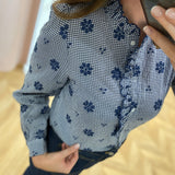 Vue rapprochée de la patte de boutonnage volantée et du motif vichy bleu de la chemise Summer