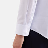 Zoom sur le poignet réglable et la broderie rose emblématique de la chemise SEIDENSTICKER