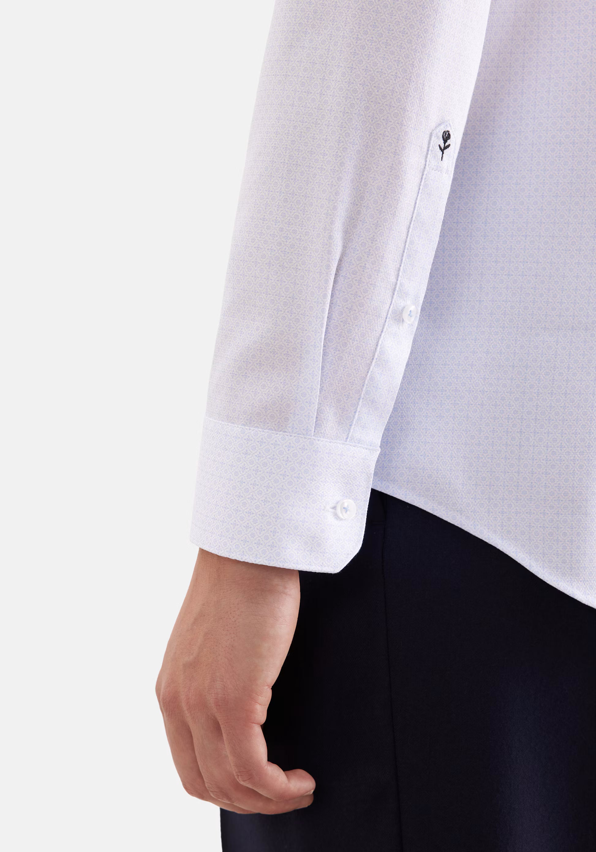Zoom sur le poignet réglable et la broderie rose emblématique de la chemise SEIDENSTICKER