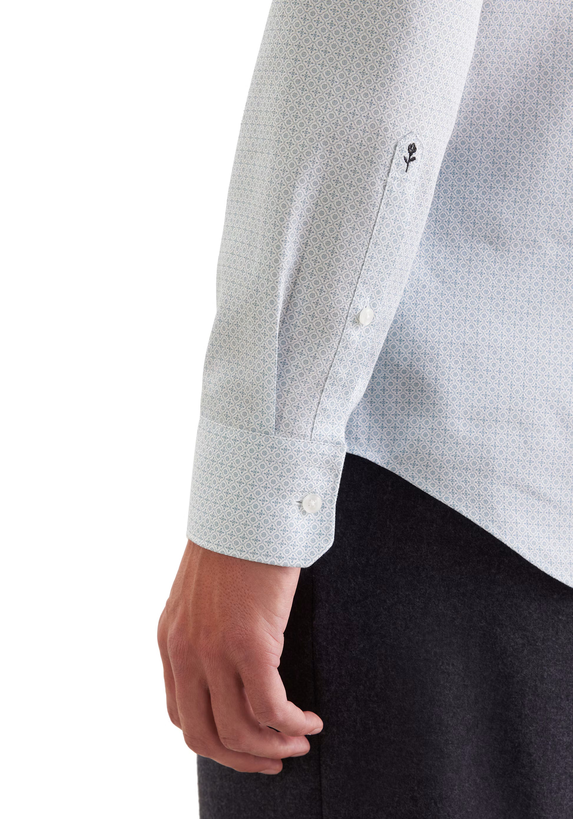 Zoom sur le poignet réglable et la broderie rose emblématique de la chemise vert SEIDENSTICKER