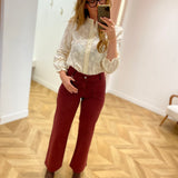 Vue en pied de la blouse écru IN APRIL 1986 portée avec un pantalon bordeaux et des bottines