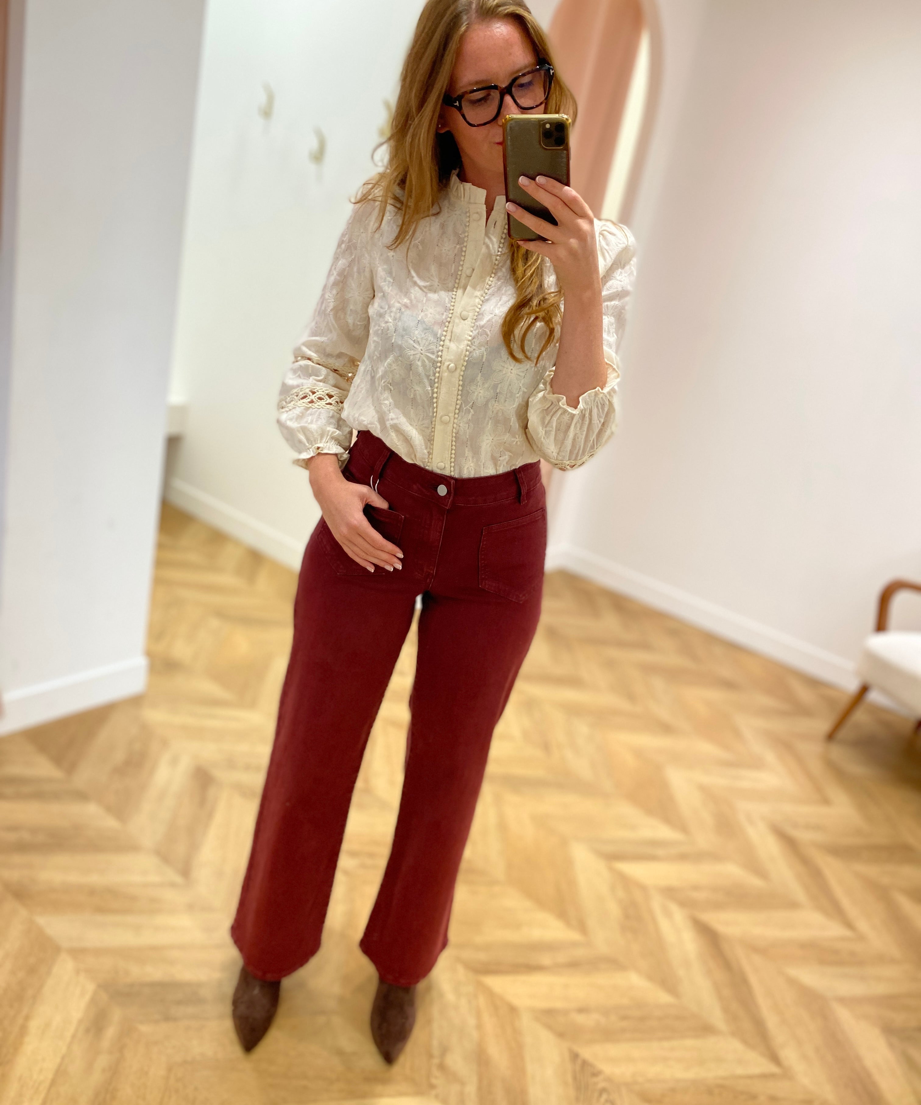 Vue en pied de la blouse écru IN APRIL 1986 portée avec un pantalon bordeaux et des bottines