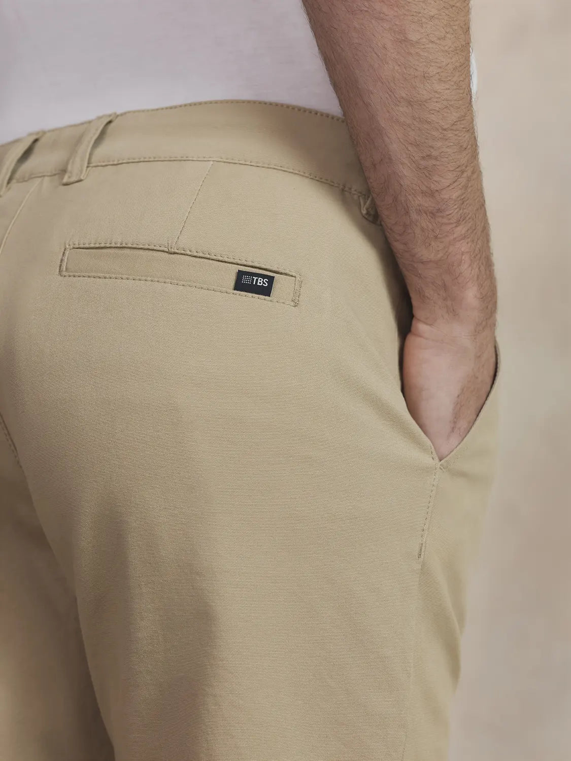 Gros plan sur la poche arrière et la petite étiquette siglée du chino beige TBS Pavlopan