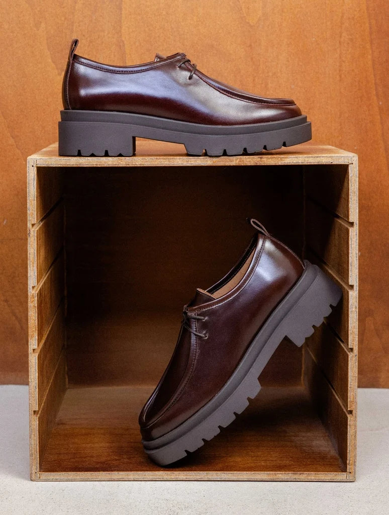 Vue des derbies bordeaux cabernet Noreen BOBBIES FEMME présentées dans un casier en bois