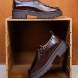 Vue des derbies bordeaux cabernet Noreen BOBBIES FEMME présentées dans un casier en bois