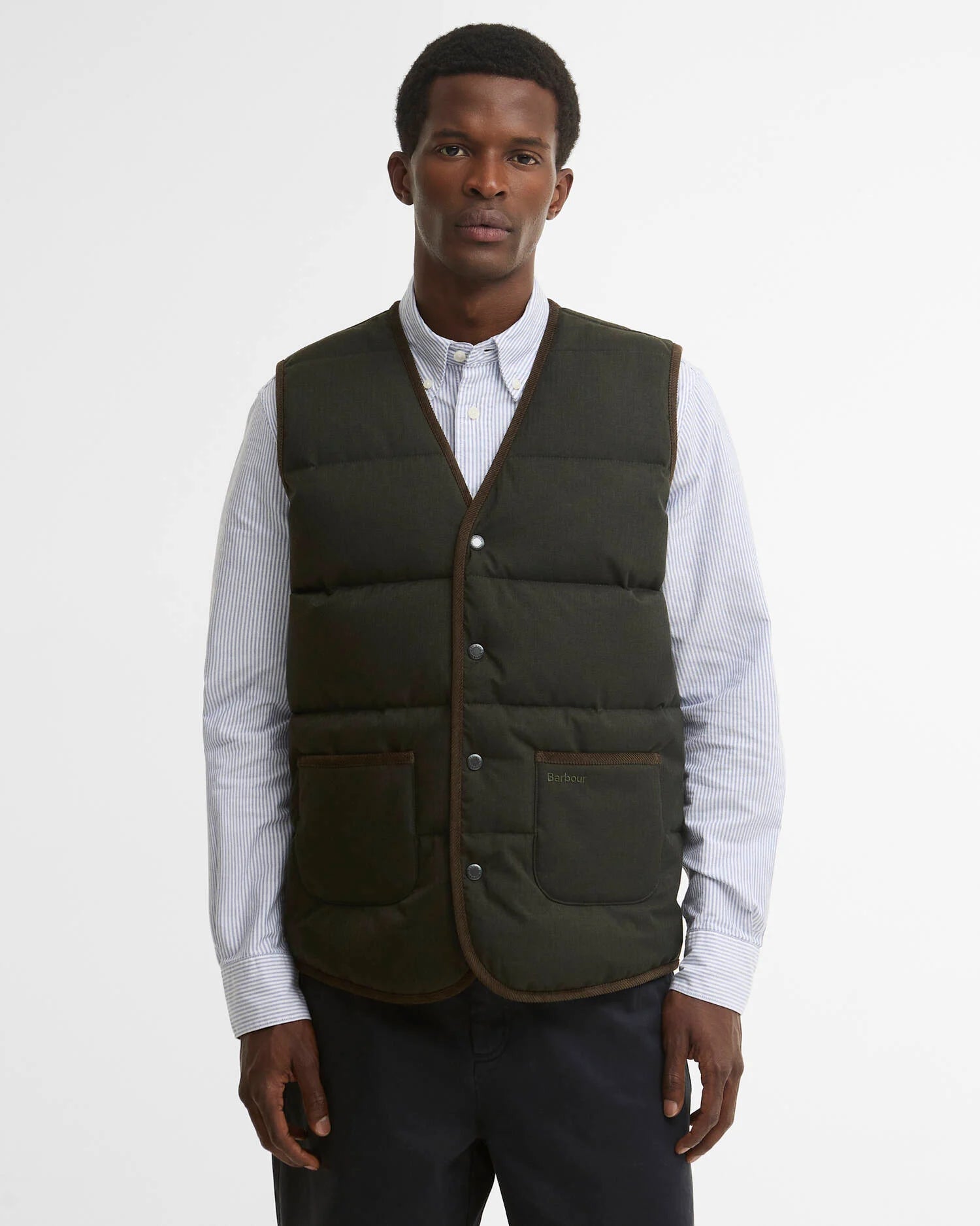 Mannequin portant le gilet matelassé sans manches Easthill sauge foncé BARBOUR HOMME sur une chemise à rayures