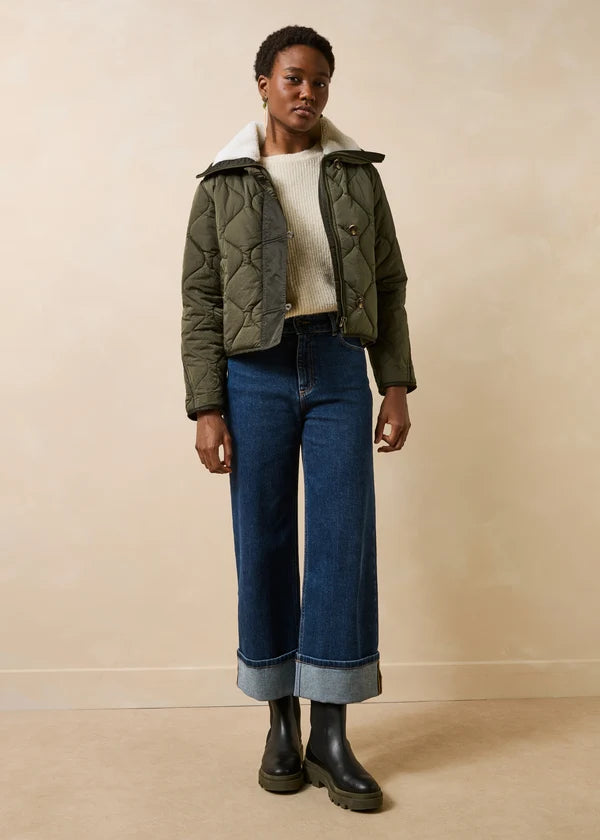 Silhouette complète portée avec la doudoune kaki Gora LA FÉE MARABOUTÉE, jean large à revers et bottines
